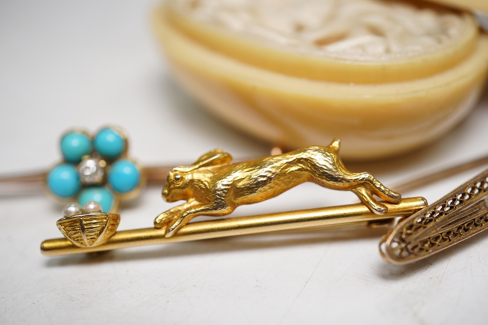 Three assorted early 20th century bar brooches, including a 14k and seed pearl set 'Easter bunny' brooch, gross 2.3 grams a 9ct turquoise and diamond cluster brooch and a 10k and gem set brooch, gross 5.2 grams. Conditio